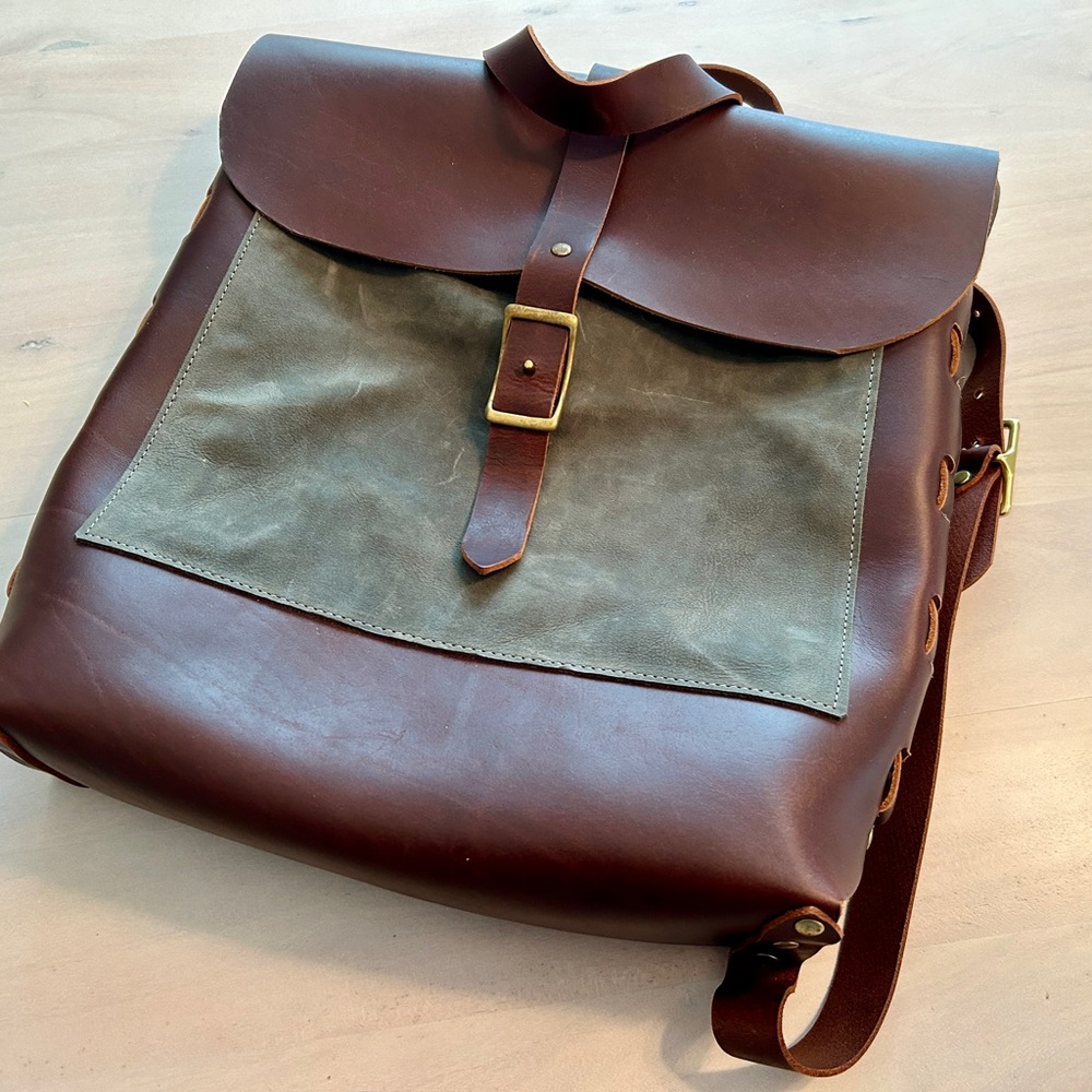 Handcrafted leather backpack with brass colored hardware